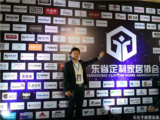 世预赛(中国)家居安装创始人卢建华先生在2018广州定制家具峰会会员企业名单墙拍照留念